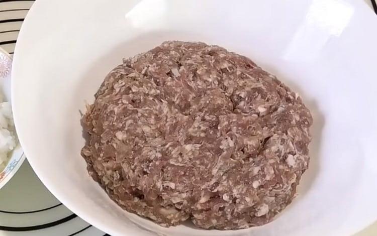 La carne macinata si mescola immediatamente con cipolle tritate e aglio.