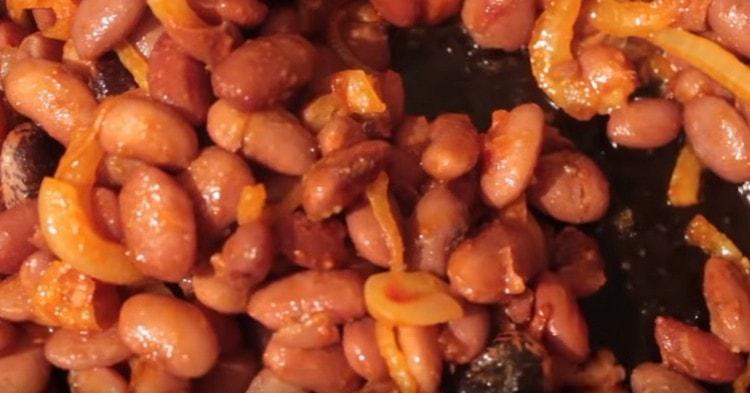Na cibuli s rajčatovou pastou převedeme vařené fazole, dokud se nevaří.