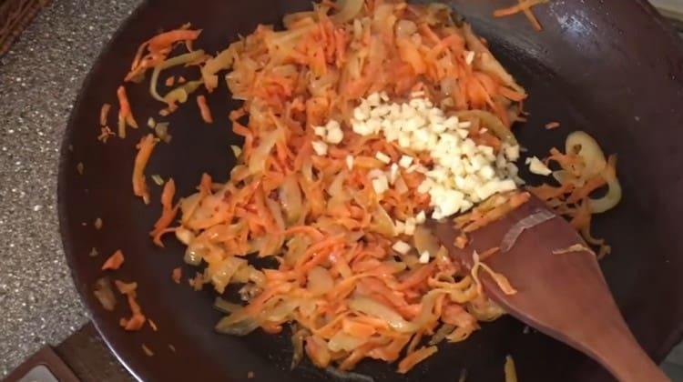 Προσθέστε ψιλοκομμένο σκόρδο στα λαχανικά στο τηγάνι.