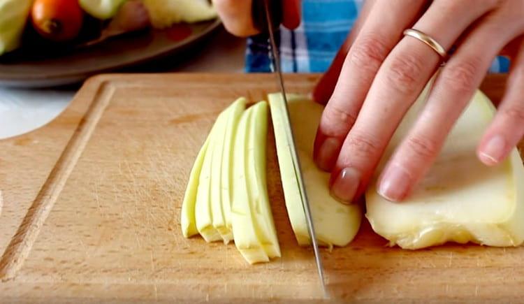Tagliare le zucchine a strisce sottili.