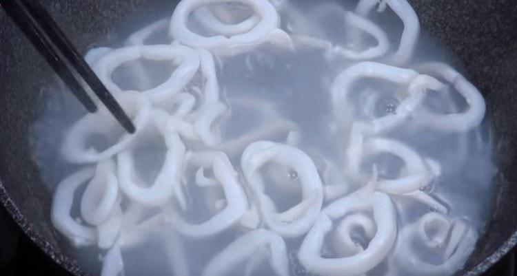 Ora fai bollire gli anelli di calamari in acqua.