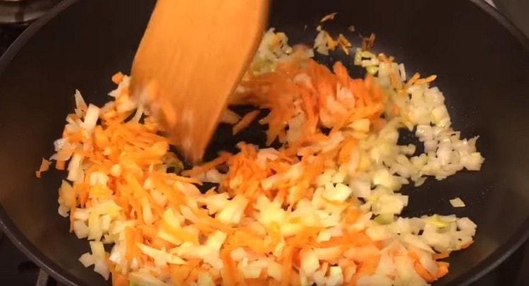 Τηγανίζουμε το κρεμμύδι με τα καρότα σε μια κατσαρόλα μέχρι να μαλακώσουμε.
