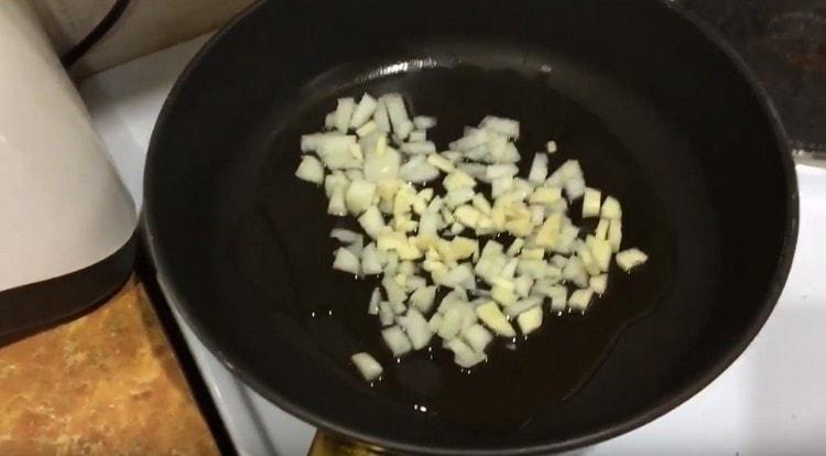 Σε μια κατσαρόλα, τηγανίζουμε τα κρεμμύδια και το σκόρδο.