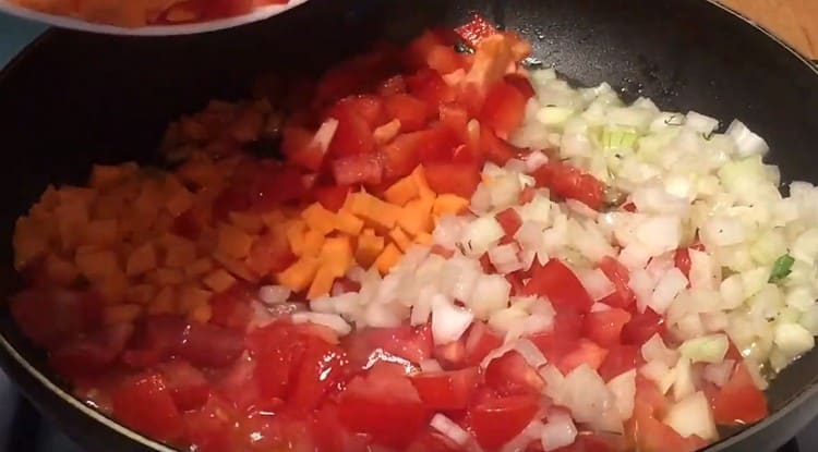 Přidejte papriku a mrkev na cibuli s rajčaty.