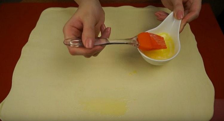 Намажете тестото с разтопено масло.