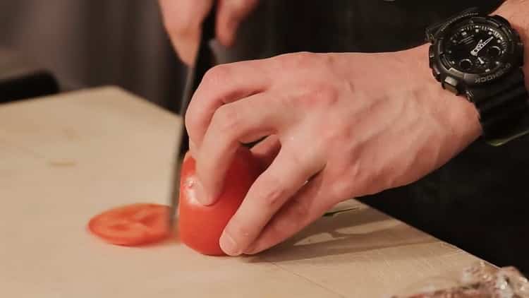 Für einen Burger eine Tomate schneiden