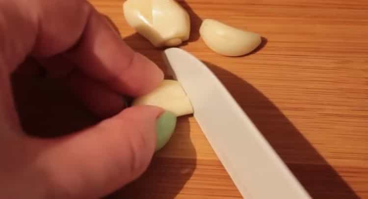 Trita l'aglio per preparare le lenticchie
