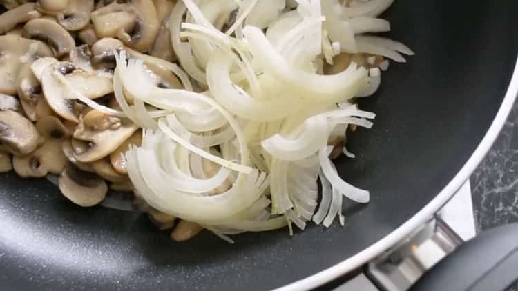 Friggi cipolle e funghi per preparare le tagliatelle.