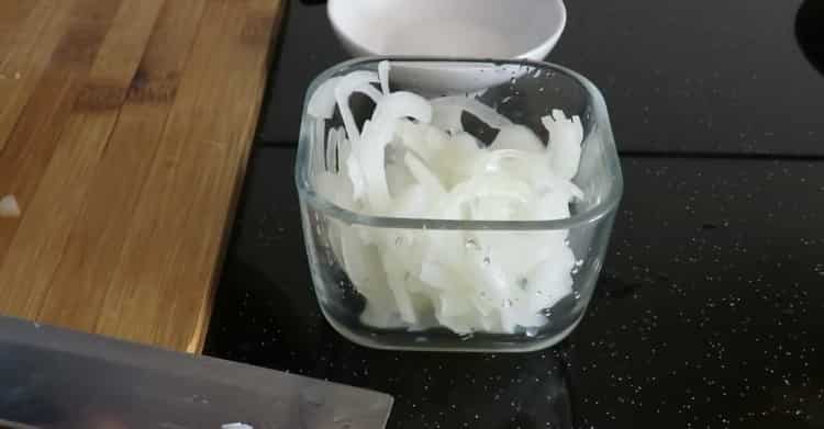 Per preparare il ripieno, tagliare la cipolla