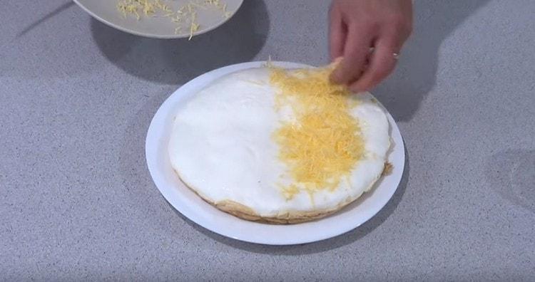 nastrouhejte strouhaný sýr na polovinu omelety.