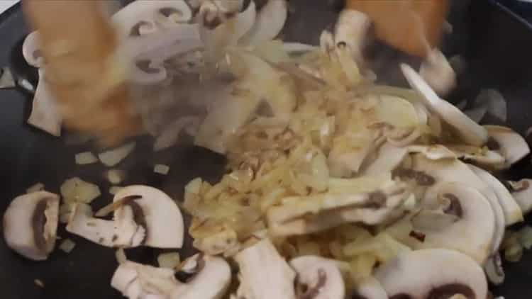 Friggere i funghi per fare una pasta.