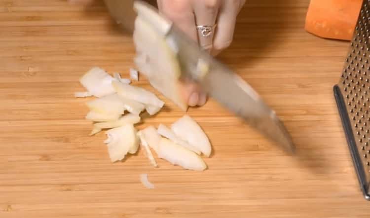 Per preparare involtini di cavolo, tritare la cipolla
