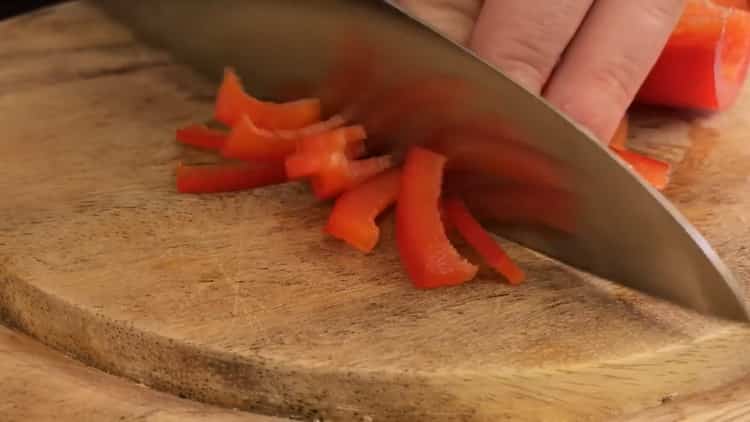 Zum Kochen von Fischfleischbällchen Zwiebeln hacken