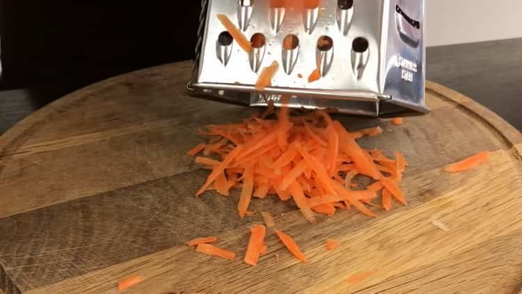 Zum Kochen von Fischfleischbällchen Karotten raspeln