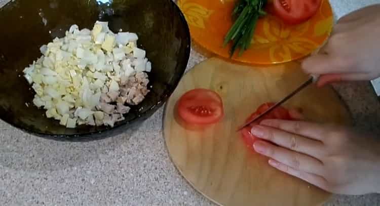 Per preparare un'insalata, tagliare i pomodori