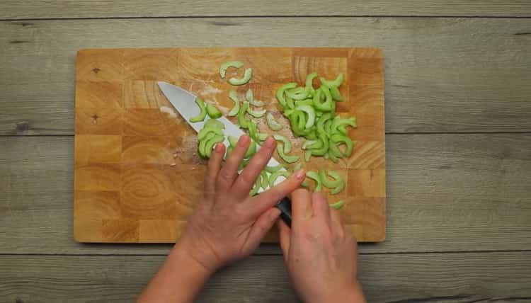 Schneiden Sie eine Gurke, um einen Salat zu machen