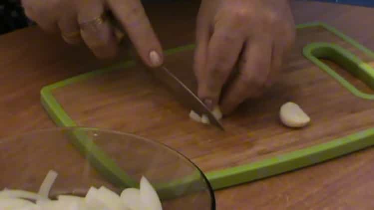 Den Knoblauch hacken, um einen Salat zu machen