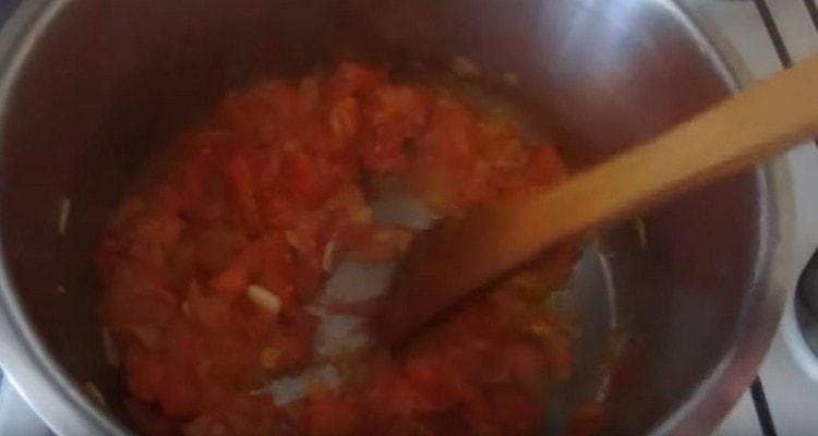 Fügen Sie die geschnittene Tomate der Zwiebel hinzu.