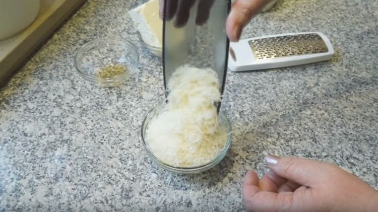 Strofina il parmigiano su una grattugia.