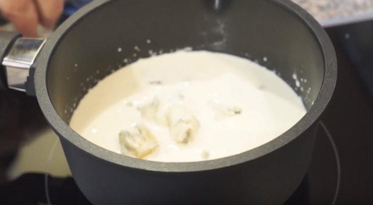 Rupeți gorgonzolla în bucăți și întindeți-l în smântână fierbinte.