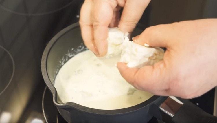 Fügen Sie den gebrochenen Käse in Stücke in der Soße hinzu.