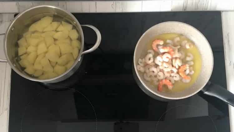Friggere i gamberi per preparare la zuppa.