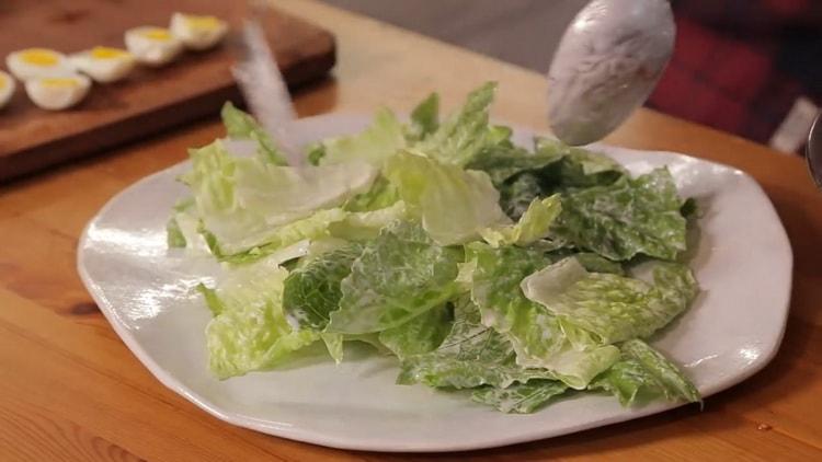 Um den Salat zuzubereiten, legen Sie den Salat auf einen Teller