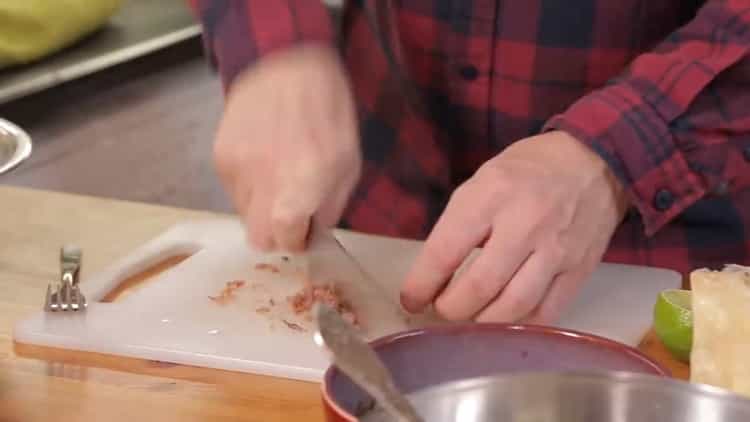 Per preparare un'insalata, tritare le acciughe