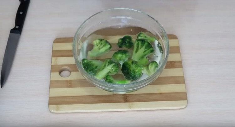 Tauchen Sie den gefrorenen Brokkoli in eine Schüssel mit Wasser.