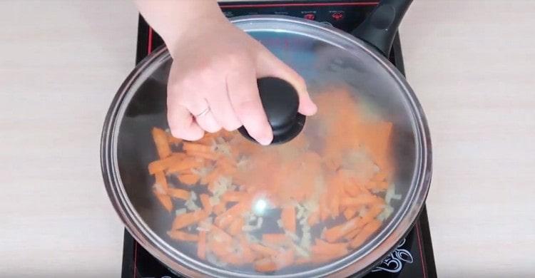 Stufare le cipolle con le carote per diversi minuti sotto il coperchio.
