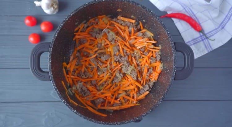 Добавете морковите към лука с месото.