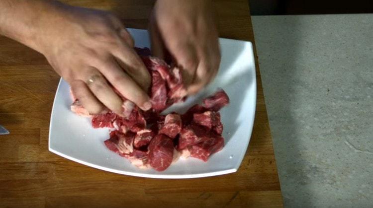Mėsą supjaustykite gabalėliais, pagardinkite druska ir pipirais.