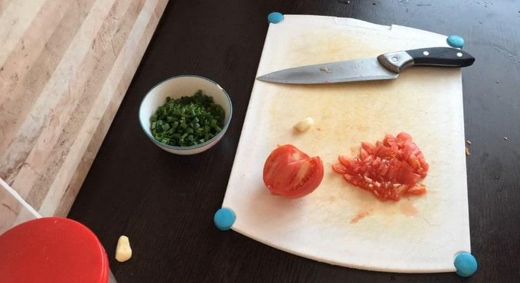 Pomidorą supjaustykite griežinėliais, supjaustykite žalumynus ir česnaką.