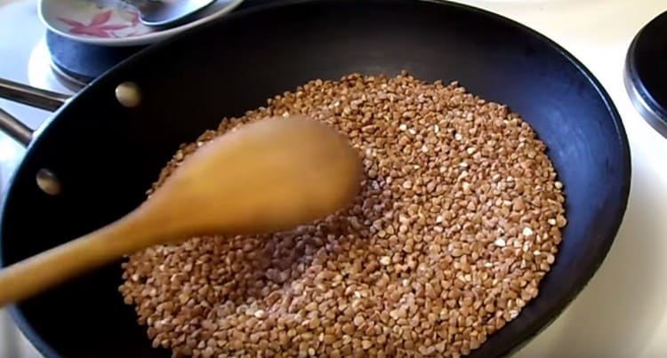 Una, magprito ng dry cereal sa isang kawali.