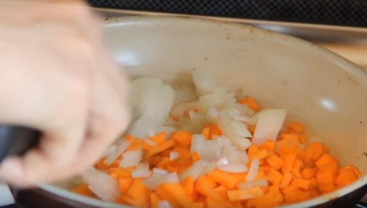 In olio vegetale, friggi le cipolle e le carote.
