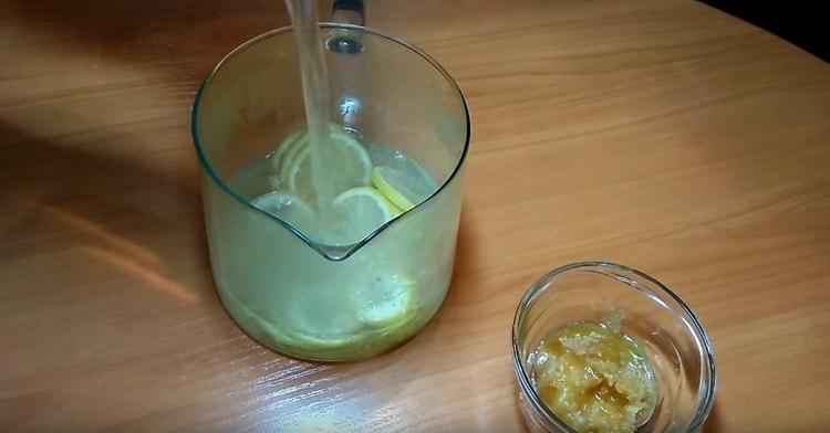 Wir verteilen die Zitrone und den Ingwer in einer Teekanne und gießen kochendes Wasser ein.