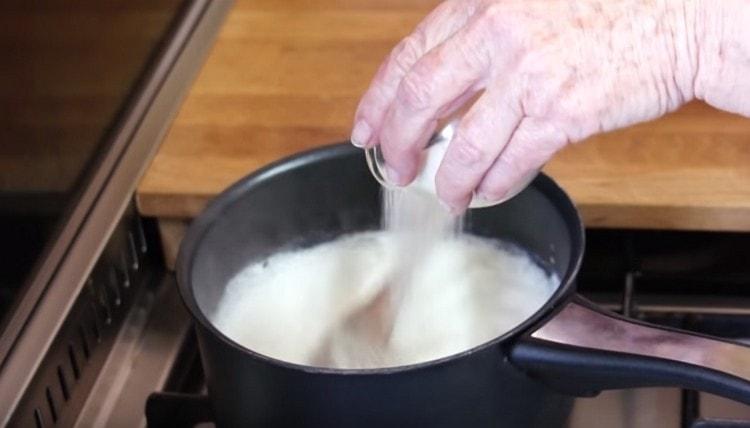 Wir gießen nach und nach Grieß unter ständigem Rühren in die gekochte Milch.
