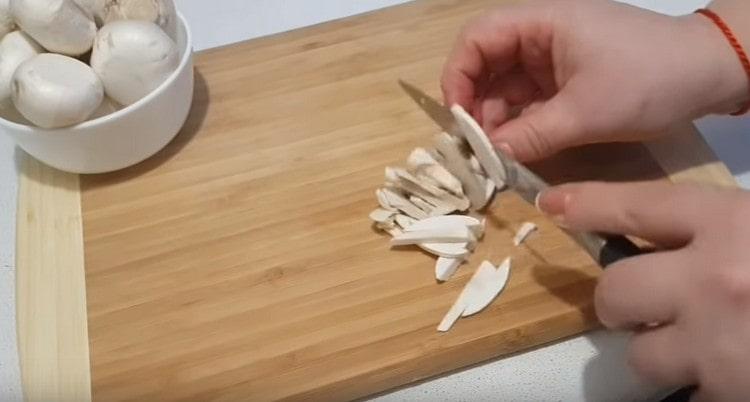 Κόψτε τα μανιτάρια σε λεπτές φέτες.