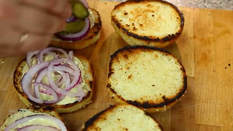 Per preparare un hamburger, metti la cipolla su un panino