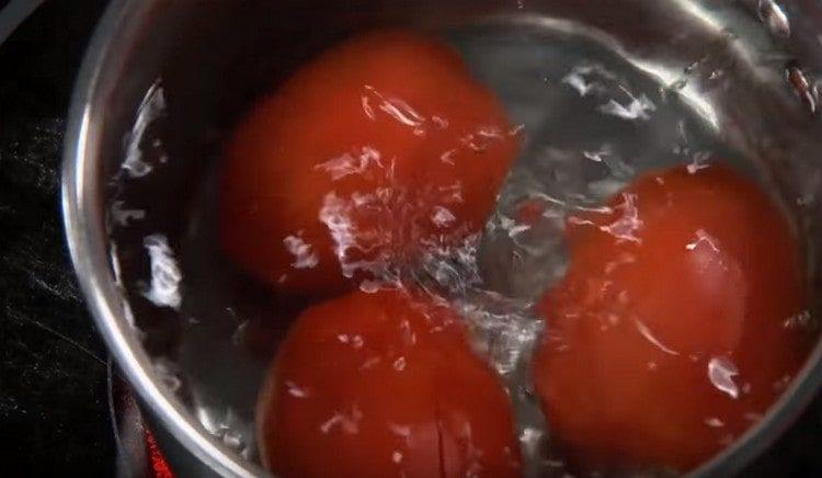 Разпределяме доматите във вряща вода.