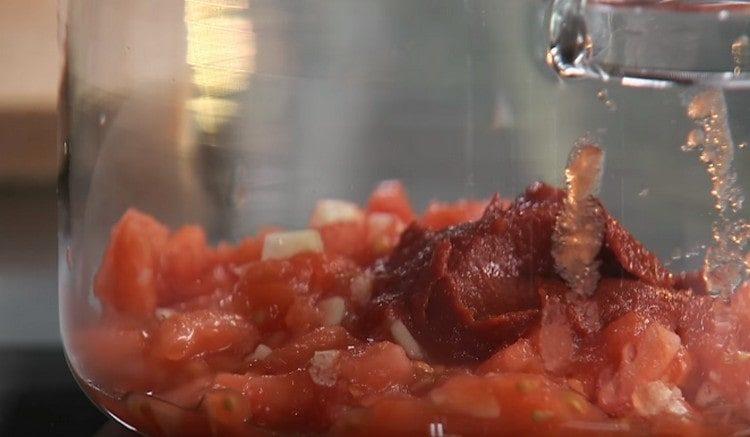 Į pomidorus įpilkite pomidorų pastos su česnaku.