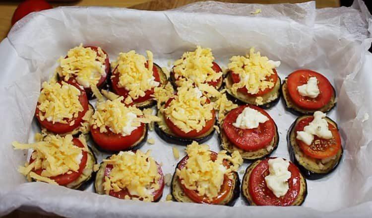 Verteilen Sie den Frischkäse auf den Tomaten und bestreuen Sie ihn mit geriebenem Käse.