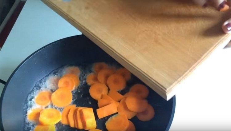 ψιλοκόβουμε τα καρότα και το τηγανίζουμε σε μια κατσαρόλα.