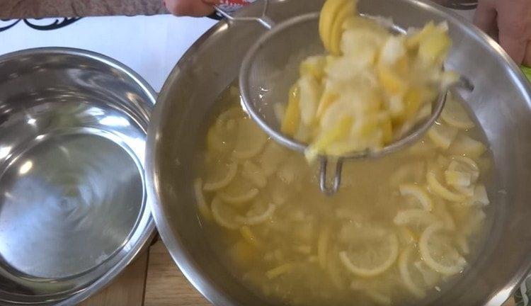 Die gekochten Zitronen werden aus dem Wasser genommen.