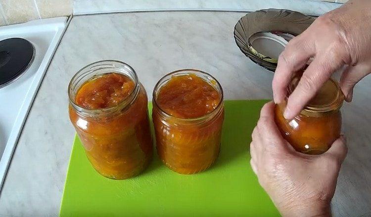 Wir legen Kürbismarmelade mit getrockneten Aprikosen in sterilisierte Gläser und drehen die Deckel.