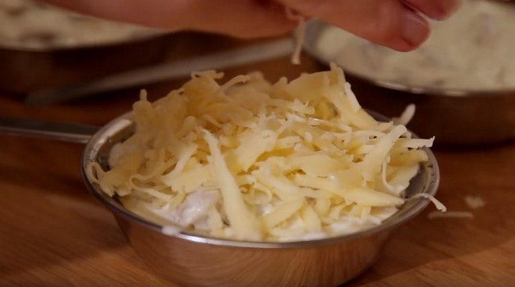 Megszórjuk a tál minden egyes részét reszelt sajttal.