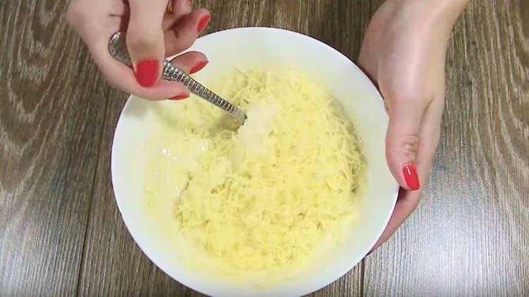 В тестото добавете настърганото сирене и разбъркайте.