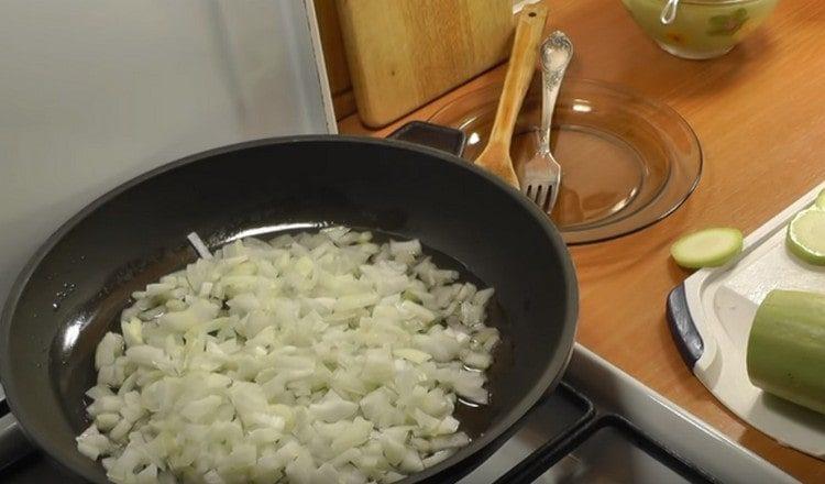 Τρίψτε τα κρεμμύδια και τα απλώστε σε ένα τηγάνι.