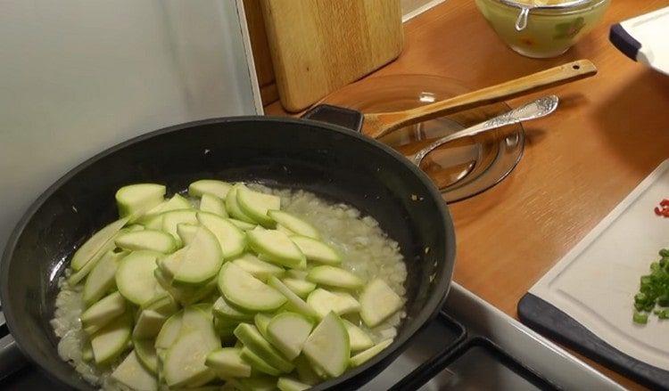 Wir verteilen die geschnittenen Zucchini in der Pfanne.