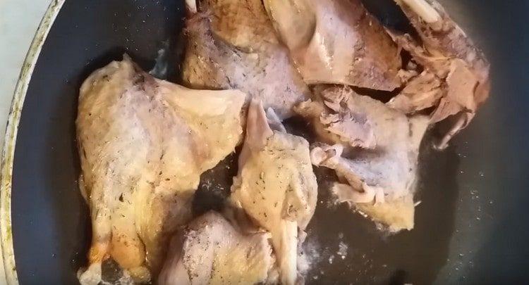 Wir verteilen Entenfleisch in einer erhitzten Pfanne mit Pflanzenöl.